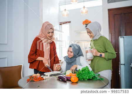 woman wearing hijab with best friend preparing food for dinner woman wearing hijab with best friend preparing food for dinner 99817583