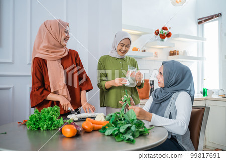 muslim woman cooking for dinner at friends home during ramadan 99817691