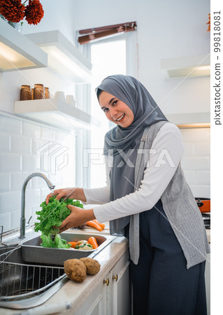 muslim woman friend preparing some food for dinner muslim woman friend preparing some food for dinner 99818081