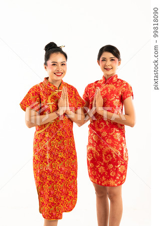 two young wowoman men in cheongsam standing together with hands put together two young wowoman men in cheongsam standing together with hands put together 99818090