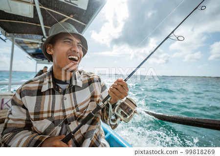 fisherman shouts as hook is eaten by fish while fishing fisherman shouts as hook is eaten by fish while fishing 99818269
