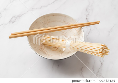 Dried udon nudles in a bowl closeup. Dried udon nudles in a bowl closeup. 99818485