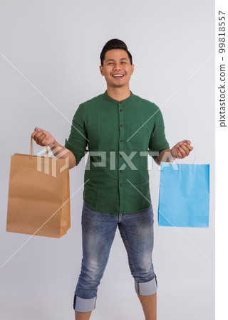 asian man standing with the shopping bags at his hands asian man standing with the shopping bags at his hands 99818557