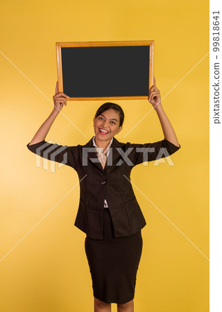 asian woman in formal outfit holding the blackboard up 99818641
