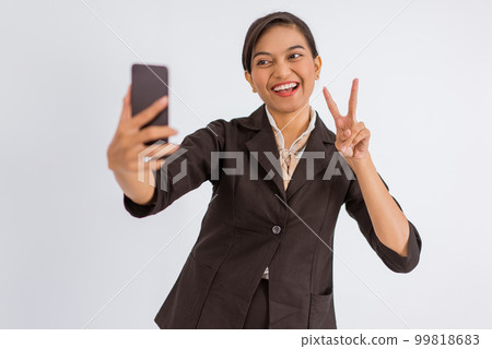 asian woman standing with peace hand gesture while taking selfie photo 99818683