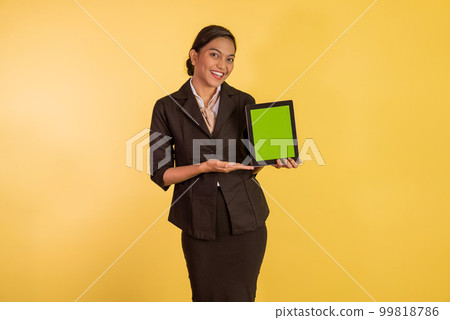 woman in formal outfit showing and pointing on the digital tablet 99818786