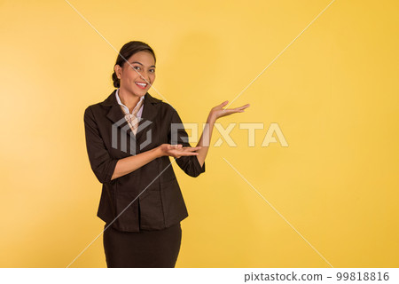 asian woman in formal outfit standing an pointing on her side 99818816