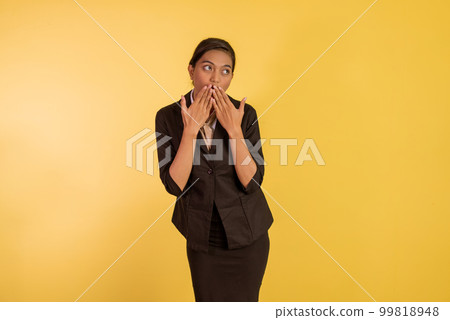 shocked asian woman in formal outfit closing her mouth with her hands 99818948