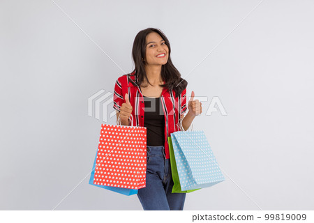 asian woman standing with thumbs up and bring a lot of shopping bags 99819009