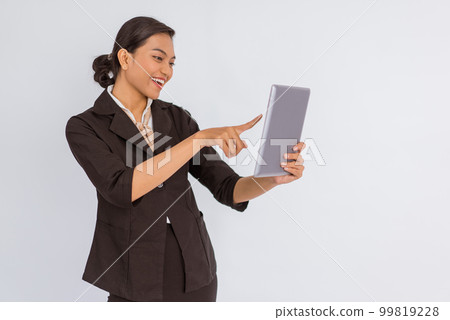 beautiful woman in formal outfit looking and pointing on the digital tablet beautiful woman in formal outfit looking and pointing on the digital tablet 99819228