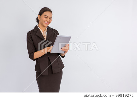 woman in formal outfit standing with smile while using the digital tablet 99819275