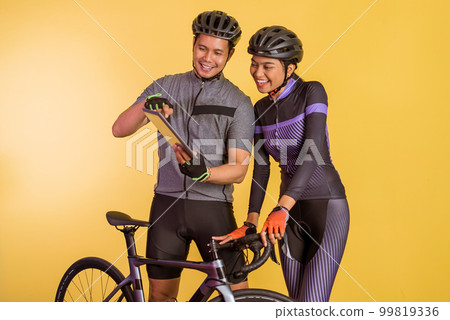 asian couple in cycling outfit using the digital tablet 99819336
