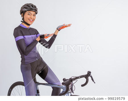 asian woman sitting on her bike while pointing on her side asian woman sitting on her bike while pointing on her side 99819579