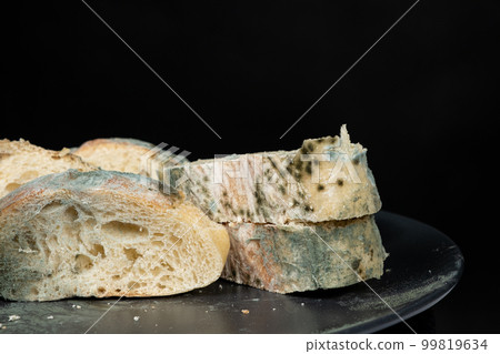 Mold on bread on a black background close-up. The danger of mold, stale products. Mold on bread on a black background close-up. The danger of mold, stale products. 99819634