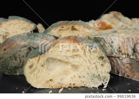 Mold on bread on a black background close-up. The danger of mold, stale products. 99819636