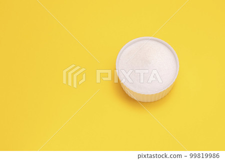 Natural organic sweetener Erythritol, produced by fermentation from corn, called dextrose in ceramic bowl on yellow orange background. Sugar substitute. Horizontal plane, copy space for text,top view Natural organic sweetener Erythritol, produced by fermentation from corn, called dextrose in ceramic bowl on yellow orange background. Sugar substitute. Horizontal plane, copy space for text,top view 99819986