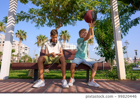 Boys hanging out playing games on smartphone. Modern communication and gadget addiction concept. Boys hanging out playing games on smartphone. Modern communication and gadget addiction concept. 99820446