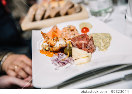 Restaurant concept, appetizer consisting of grilled shrimp, tartare, sauce, onion, tomato, lettuce Restaurant concept, appetizer consisting of grilled shrimp, tartare, sauce, onion, tomato, lettuce 99823044