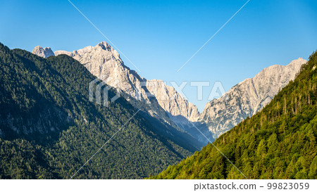 Triglav, the highest mountain in Slovenia. View from the Vrata Valley of the rocky summit and forested slopes of surrounding hills on a clear summer day Triglav, the highest mountain in Slovenia. View from the Vrata Valley of the rocky summit and forested slopes of surrounding hills on a clear summer day 99823059