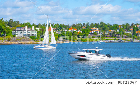 Sailboat and a motorboat by the shore of the Swedish Archipelago on a sunny day 99823067