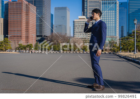 businessman talking on smartphone businessman talking on smartphone 99826491