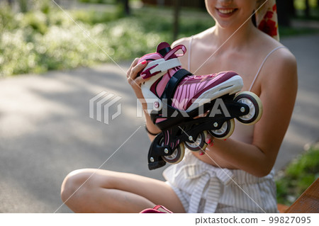Skater girl sitting on a park bench. Skater girl sitting on a park bench. 99827095
