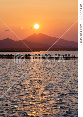 Mt.Tsukuba seen from Lake Kasumigaura at dusk and the sun on its summit Mt.Tsukuba seen from Lake Kasumigaura at dusk and the sun on its summit 99827456