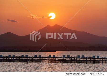 Mt.Tsukuba seen from Lake Kasumigaura at dusk and the sun on its summit Mt.Tsukuba seen from Lake Kasumigaura at dusk and the sun on its summit 99827457