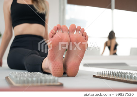 Close-up on the feet of a woman after standing on the nails of a sadhu. 99827520