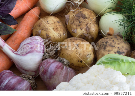 autumn harvest, composition of vegetables, potatoes and garlic next to carrots and onions autumn harvest, composition of vegetables, potatoes and garlic next to carrots and onions 99837211