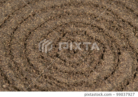 Spiral poured ground black pepper background. Dry seasoning pepper. Spices and herbs for cooking, pepper powder Spiral poured ground black pepper background. Dry seasoning pepper. Spices and herbs for cooking, pepper powder 99837927
