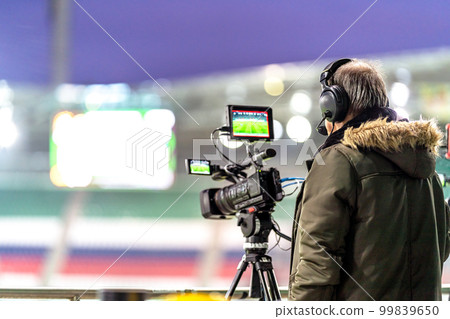 cameraman with a professional video camera on the broadcast of a football match cameraman with a professional video camera on the broadcast of a football match 99839650