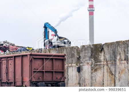 a stack of iron loaded on a train and a smoking chimney a stack of iron loaded on a train and a smoking chimney 99839651