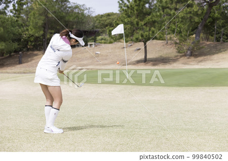 A golf girl approaching the green by hitting the ball A golf girl approaching the green by hitting the ball 99840502