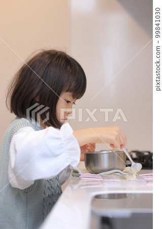 Elementary school girl (8 years old) making white chocolate Elementary school girl (8 years old) making white chocolate 99841030