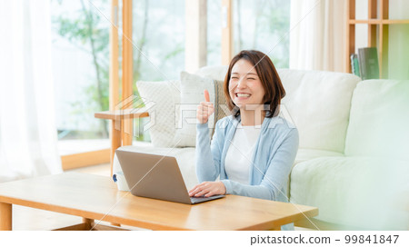 Female living room computer thumbs up 99841847