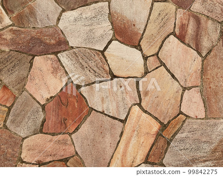 The background image of the surface of light brown rough paving stones 99842275
