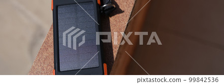 Solar power bank recharging by sunlight outdoor closeup 99842536