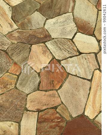 A vertical background image of a rough paving stone surface in dark ocher color 99842611