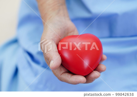 Asian elder senior woman patient holding red heart in hospital. Asian elder senior woman patient holding red heart in hospital. 99842638