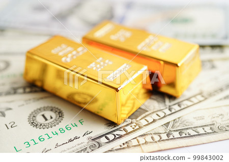 Gold bars on US dollar banknote money, finance trading investment business currency concept. Gold bars on US dollar banknote money, finance trading investment business currency concept. 99843002