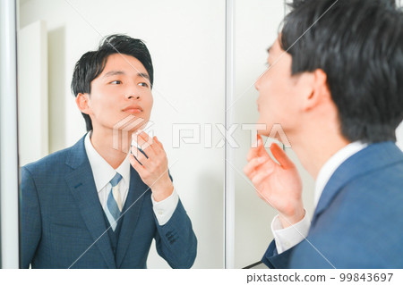 A young office worker who cares about rough skin in front of the mirror A young office worker who cares about rough skin in front of the mirror 99843697