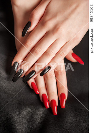 Hands of a young girl with black and red manicure on nails 99845108