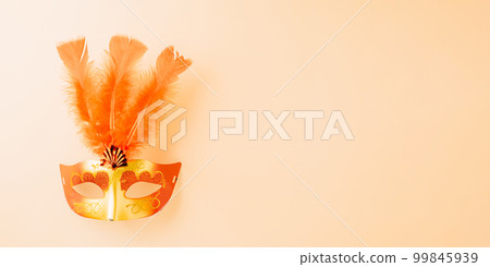 Happy Purim carnival decoration. Top view venetian ball mask with red feather on pastel background with copy space, Masquerade party, Jewish Purim in Hebrew, holiday background banner design 99845939