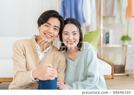 放鬆在客廳的一對年輕夫婦 99846193