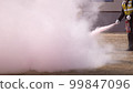 Training with a fire extinguisher extinguishing the fire 99847096