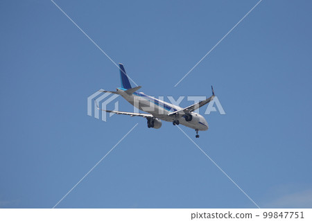 In the blue sky, a jet airliner entering the landing system 99847751