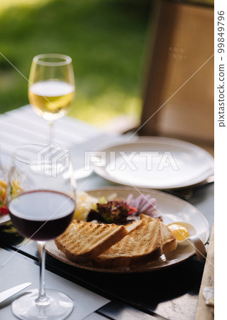 Beef tartar with grated butter and raw chicken yolk served with roasted bread. Glass of white and red wine Beef tartar with grated butter and raw chicken yolk served with roasted bread. Glass of white and red wine 99849796
