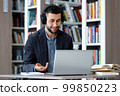 Man having teleconference using headphones and laptop 99850223