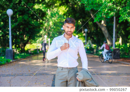 Indian businessman taking off his suit jacket and fanning himself with his shirt Indian businessman taking off his suit jacket and fanning himself with his shirt 99850267